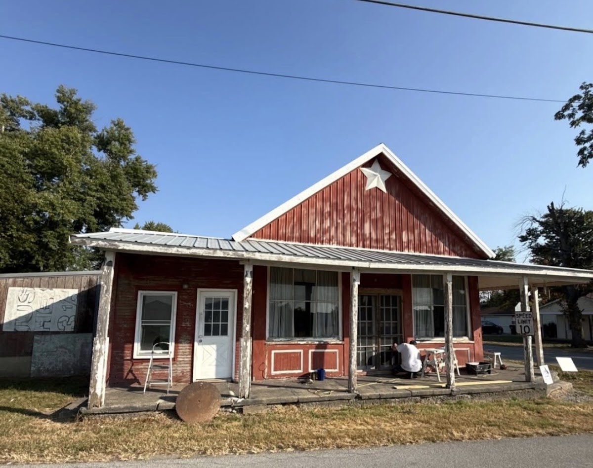 Red barn style building being painted